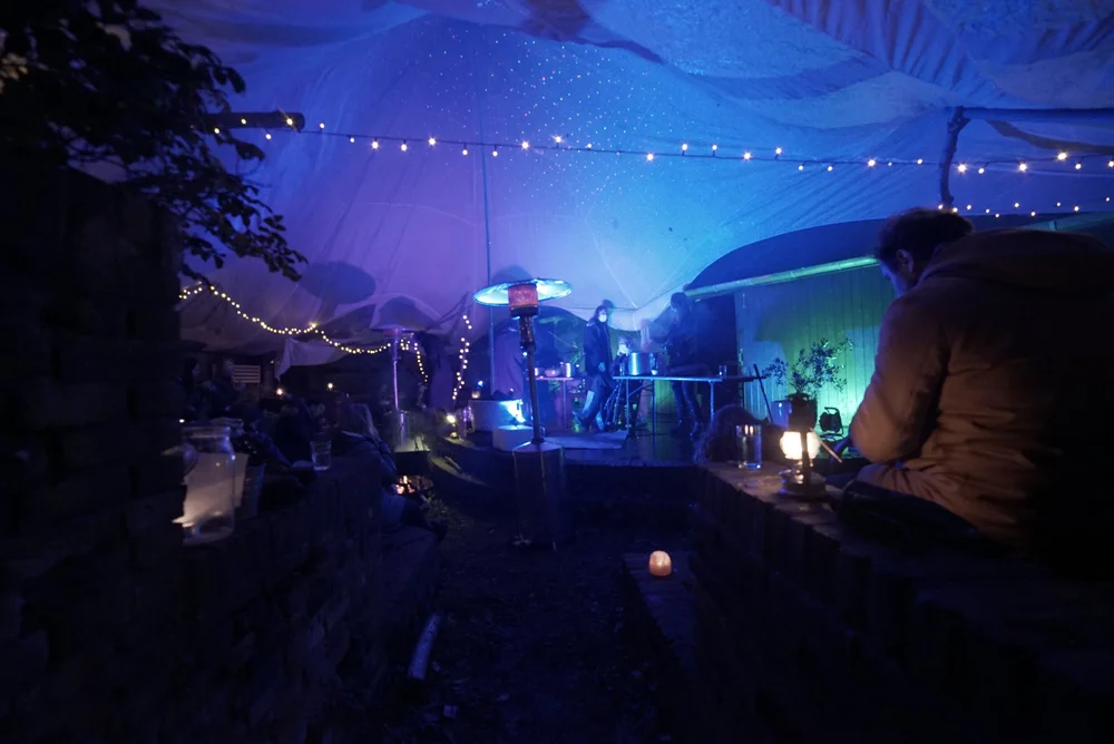 A band playing under blue lights at night