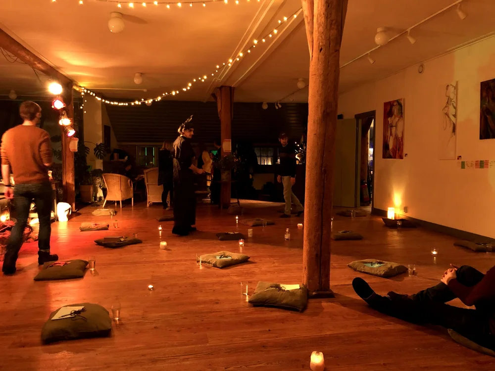 A warmly lit hall with candles on the floor