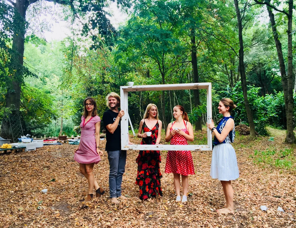 Participants in costume posing with an empty picture frame